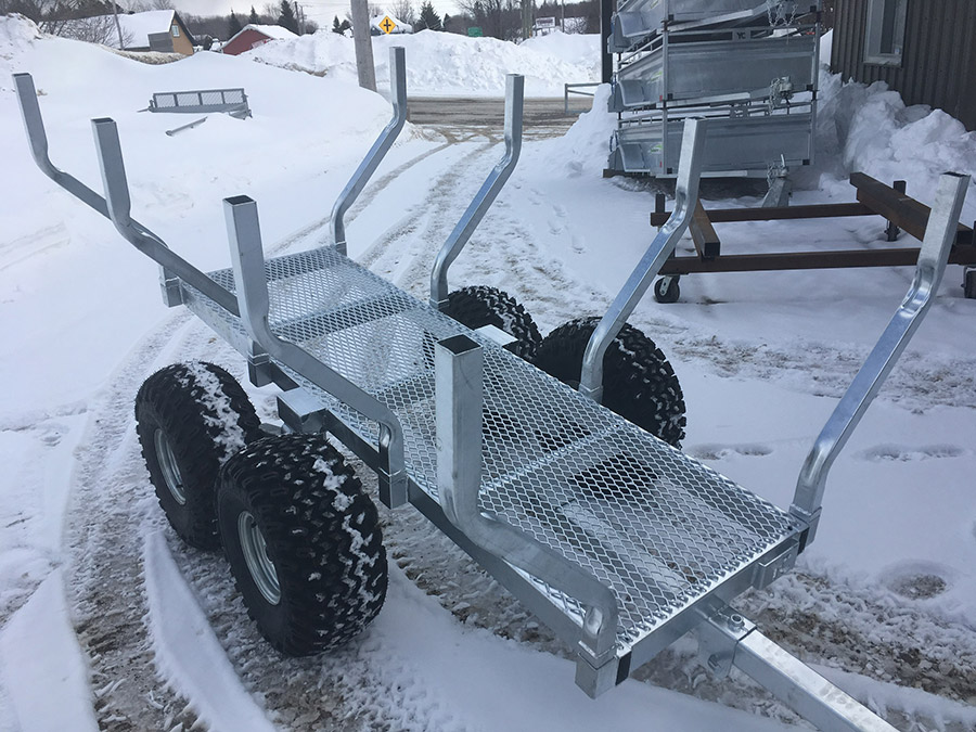 Une remorque est assise dans la neige devant un bâtiment.