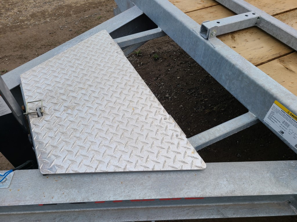 Une plaque métallique avec un motif en losange est posée sur le dessus d'une remorque.