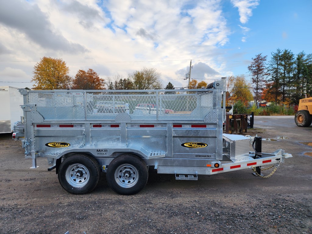 Une remorque à benne basculante est garée dans un parking.
