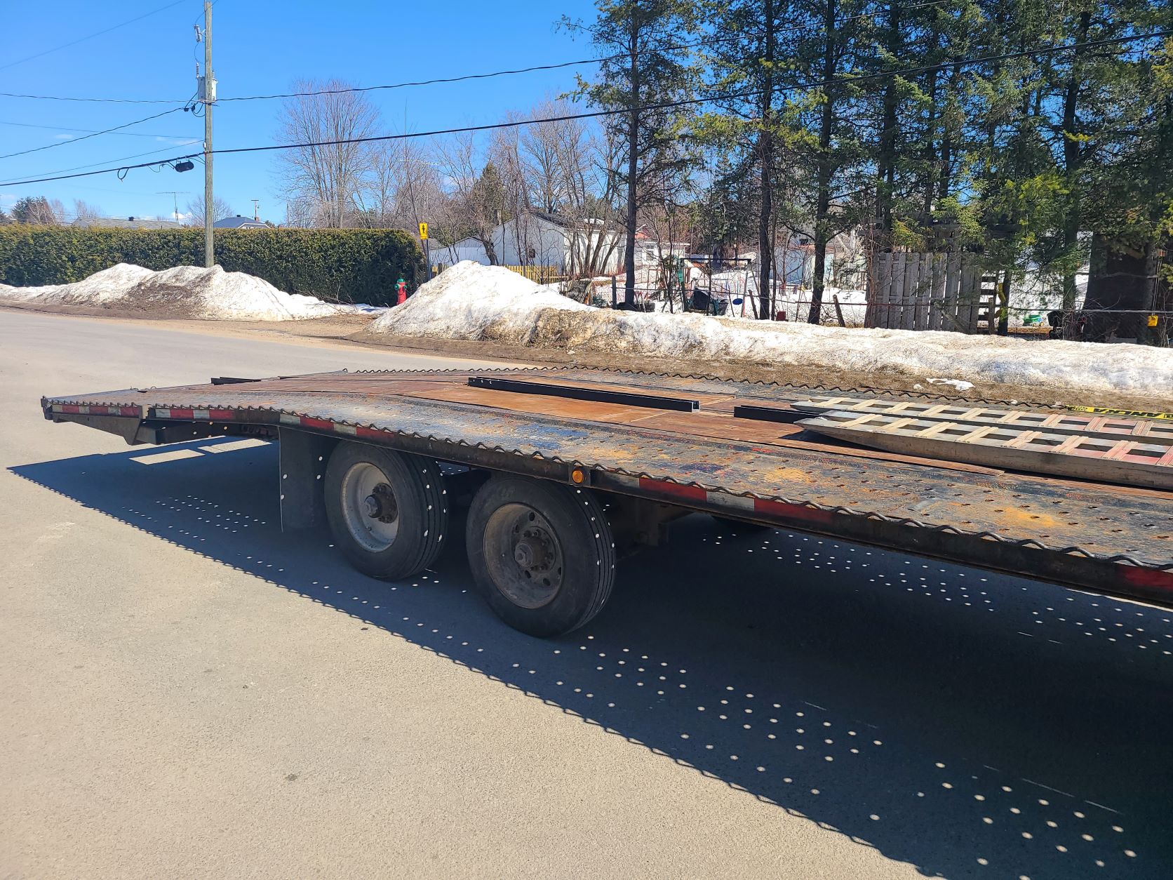 Une remorque à plateau est garée sur le bord de la route