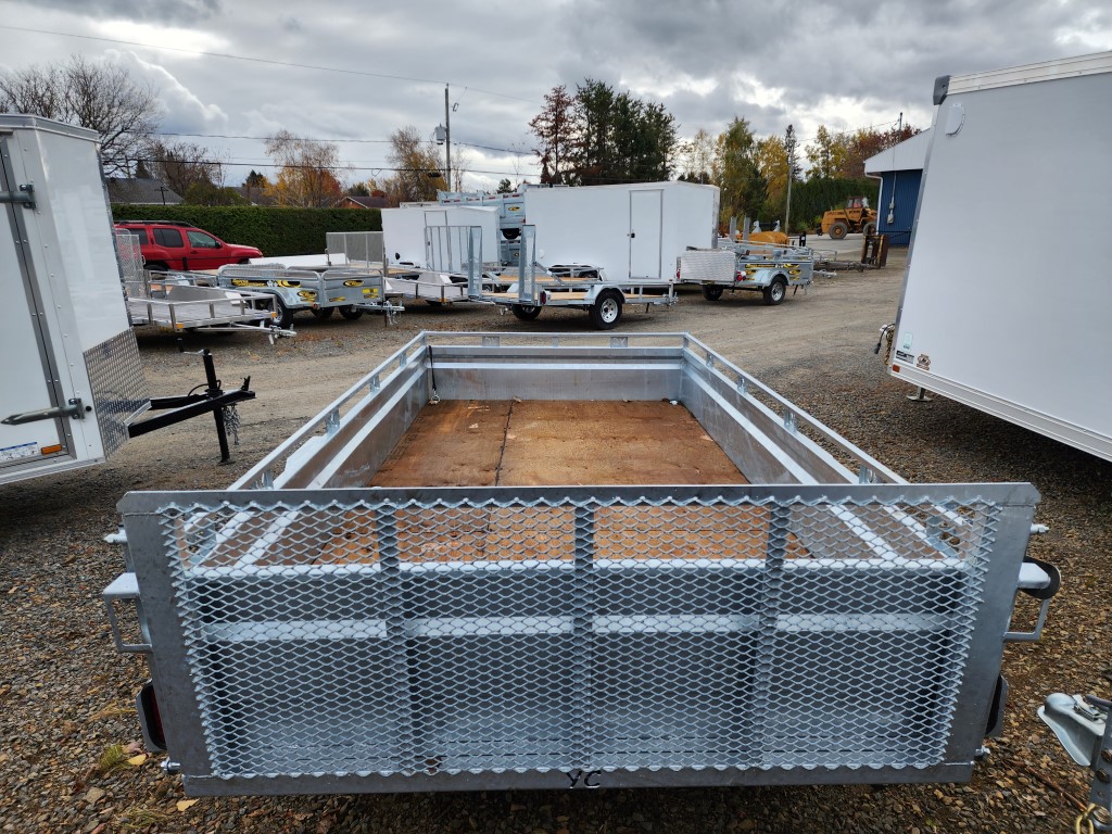 Une remorque est garée dans un terrain en gravier avec d'autres remorques.