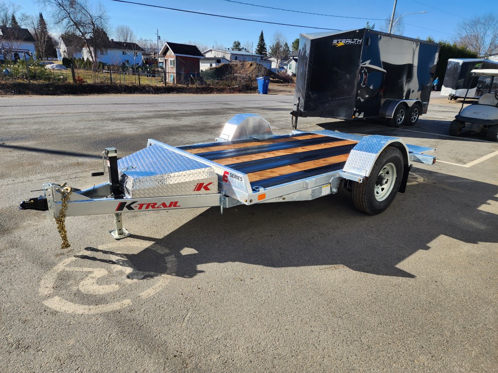 Une remorque de moto est garée sur une place de stationnement réservée aux handicapés.