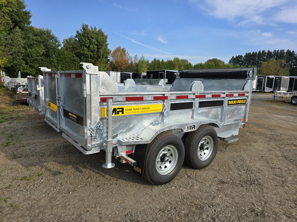 Une remorque à benne basculante est garée sur un terrain en gravier.