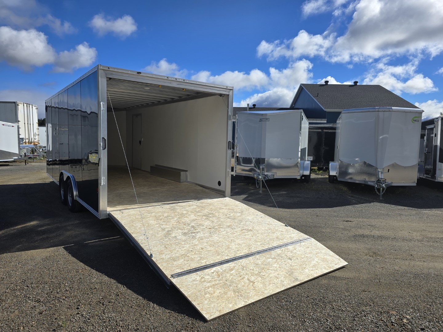 Une remorque avec la porte ouverte est garée dans un parking.