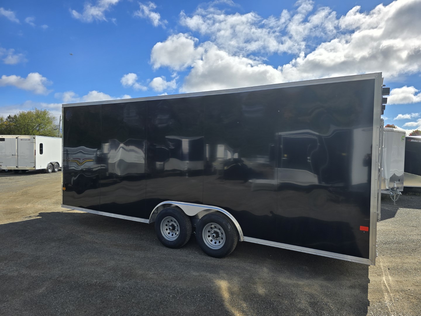 Une remorque noire est garée sur un parking.