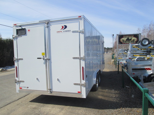 Une remorque blanche est garée sur le bord de la route