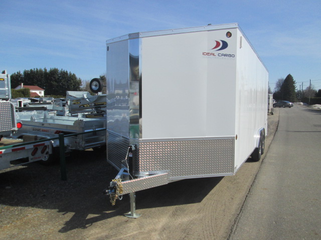 Une remorque blanche est garée sur le bord de la route.