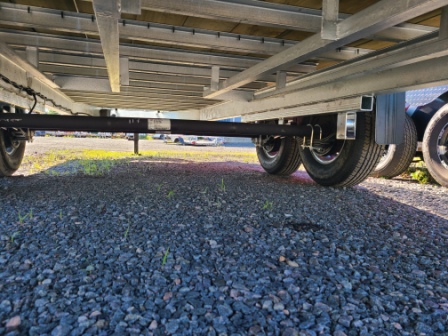 Une remorque est garée sur du gravier dans un parking.