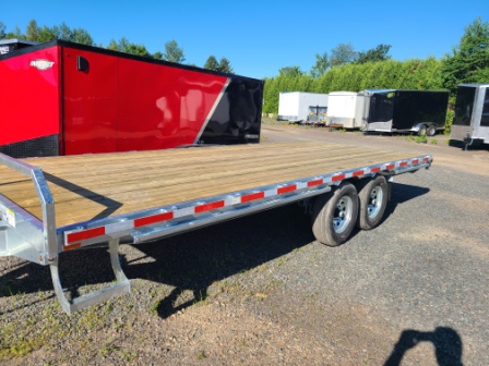 Une remorque rouge et noire est garée sur le bord de la route.