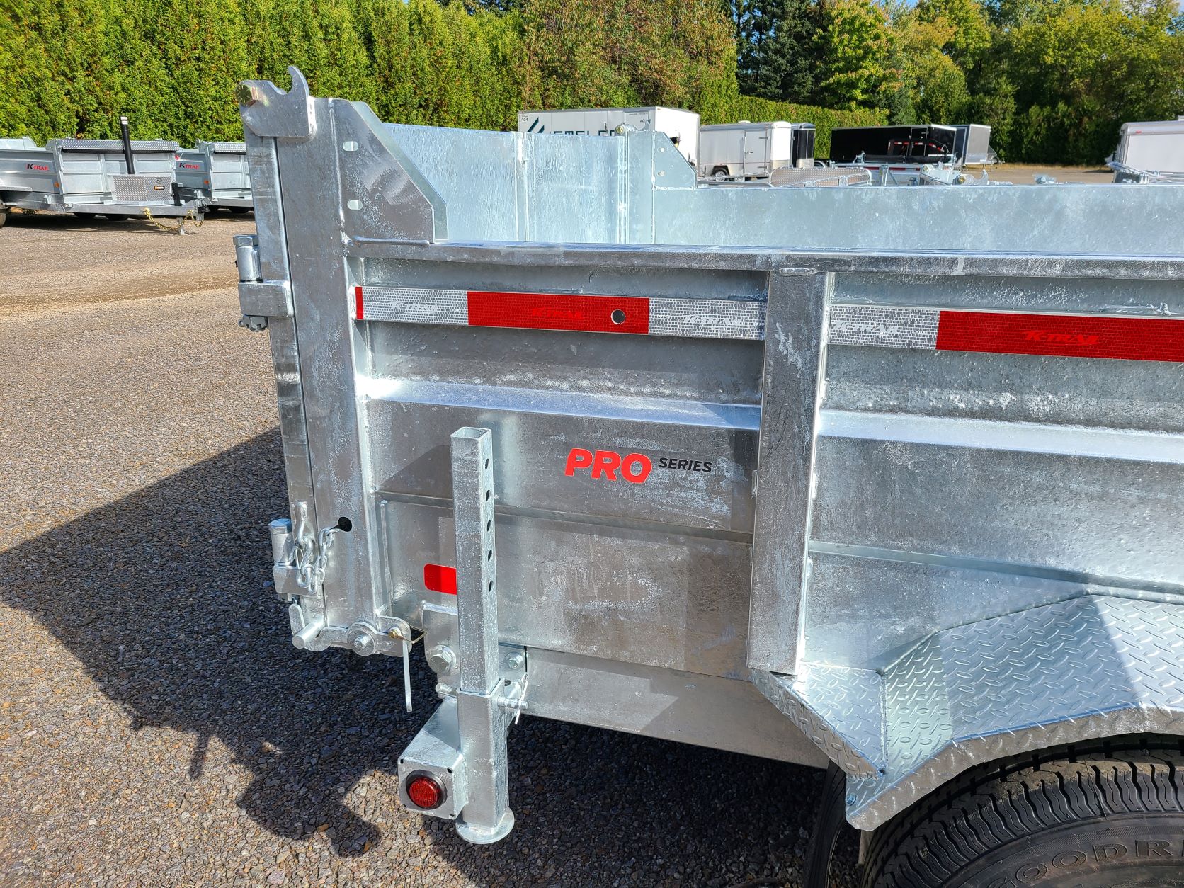 Une remorque à benne basculante est garée sur le bord de la route.